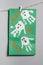 Halloween white ghosts childs handprints drawing on green paper hanging on rope on gray wall. Vertical. Handmade DIY