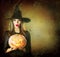 Halloween Witch holding carved pumpkin Jack Lantern