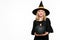 Halloween Witch holding large black pumpkin winking. Beautiful young woman in witches hat and costume holding pumpkin.