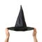 Halloween. Wizard hat in hands isolated on white