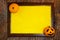 Halloween. Wooden frame with web, orange pumpkins and yellow paper blank space for text on tree bark. List for recording