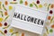 `Halloween` word on modern board, jelly monsters and worms over white wooden background, overhead view. From above
