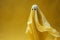 Halloweens eerie grace white ghost sheet hovers in yellow space