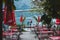 Hallstatt, Austria - June 15, 2019: couple standing at coastline looking at alpine lake cafe tables on front