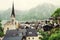 Hallstatt, Austria village, church and Alpine foggy lake, rooftops of wooden houses