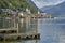 Hallstatt village landscape with old buildings reflected in blue lake with wooden decks in the foreground.