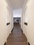 Hallway corridor in bright white colors with doors and built-in true niche with shelves and decor