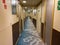 A hallway on a cruise ship with blue geometric patterned  carpet and cream colored walls