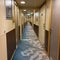 A hallway on a cruise ship with blue geometric patterned  carpet and cream colored walls