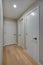 Hallway features ivory cabinets and taupe walls