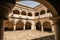 Hallway in a former 17th century Convent in central Mexico, with details of worn paint on the quarry walls and huge white arches.