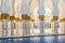 Hallway with golden decorated pillars at the entrance of the world famous Sheikh Sultan Zayed Mosque in Abu Dhabi UAE