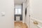 Hallway and hallway of a residential apartment with oak parquet floors, window to the interior patio with aluminum radiator below