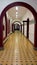 hallway with red arches and yellow floor and black squares