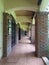 Hallway with red brick columns and brown tiled floors and cream ceiling