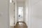 Hallway of a residential home with custom built-in wardrobes with white lacquered wooden doors and access to a sunny laundry room