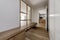 Hallway of a residential home with a long wooden bench with drawers underneath, a glass window, white built-in wardrobes and oak