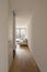 Hallway with staircase. Living room with sofa and large window to nature