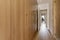 Hallway to a covered bedroom with built-in wardrobes on one side and a man looking out a window in the background