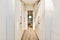 a hallway with white closets and a wood floor