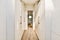 a hallway with white closets and a wood floor