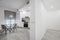 Hallway and white kitchen with circular glass dining table