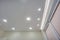 Halogen spots lamps on suspended ceiling and drywall construction in in empty room in apartment or house. Stretch ceiling white