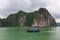 Halong Bay Rock formation with traditional blue fishing boat, UNESCO world natural heritage, Vietnam