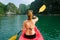 Halong Bay / Vietnam, 06/11/2017: Woman on kayak paddling through karst islands and dense jungle in Halong Bay / Cat Ba island