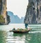 HALONG, VIETNAM - DECEMBER 16, 2016: Fisherman in a boat in the Halong bay. Copy space for text.