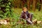 A halt in the woods. Small boy halt and relax sitting on tree in forest. Small boy resting on nature. You cant halt time
