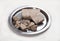 Halva in briquettes and in large pieces lies on a metal plate on a white background