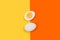 Halved boiled egg and an egg on a yellow and orange background