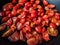 Halved cherry tomatoes in a black pan with olive oil ready to be cooked