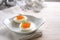 Halved eggs with red caviar and dill garnish on a light gray wooden table with Christmas decoration, festive snack for a holiday
