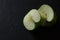 Halved green apple on black background