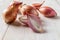Halved red eschalot and whole bulbs on a white wooden table. Unpeeled long and round shallots close-up. Raw spring onion ready for