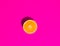 Halved Ripe Juicy Orange on Vivid Fuchsia Pink Background. Bright Harsh Sunlight Deep Shadow. Vibrant Neon Colors