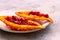 Halved ripe momordica charantia fruit or bitter melon on white ceramic plate. Selective focus. Blurred background