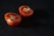 Halved tomato on black background