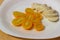 Halved yellow tomatoes and mozzarella wedges on a glossy plate
