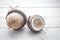 halves of coconut on a white wooden background