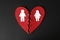 Halves of cut felt heart with paper man and woman pinned together on black background