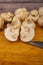 Halves of cut mushrooms and young mushrooms scattered on a wooden background. Close up