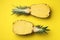 Halves of fresh pineapple on yellow background