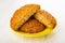 Halves of oat cookie with sunflower seeds in saucer on wooden table