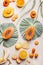 Halves of papaya with seeds on tropical leaves and various tropical fruits on withe background , top view. Exotic fruits. Healthy