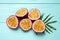 Halves of passion fruits maracuyas and palm leaf on light blue wooden table, flat lay