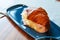 Ham and cheese croissant, hot, lies on a blue plate, pastries