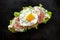 Ham and fried egg open sandwich, Sourdough bread sandwich with lettuce, ham and fried egg on a black background
